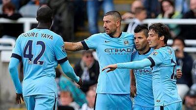 Manchester City's Spanish midfielder David Silva, right, celebrates with Manchester City Argentinian striker Sergio Aguero and Manchester City's Serbian defender Aleksandar Kolarov after Aguero's goal during the English Premier League football match between Newcastle United and Manchester City at St James' Park in Newcastle-upon-Tyne, north east England on August 17, 2014. Manchester City won the game 2-0. AFP PHOTO / IAN MACNICOL