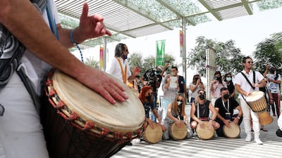 Artists play drums with visitors at the Israeli pavilion.