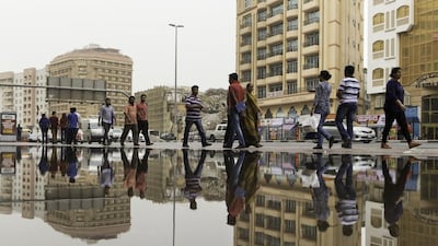Pedestrians walk along Khalid Bin Al Waleed road in the Al Raffa area of Dubai after rainfall earlier in the day. Christopher Pike / The National