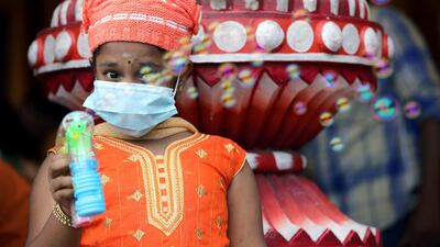 A girl wearing mask play with a bubble gun at a shrine in Batu Caves during Thaipusam, following the outbreak of a new coronavirus in China, in Kuala Lumpur, Malaysia. REUTERS