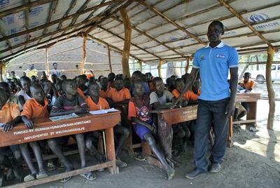 South Sudanese teacher John Idro, 28, teaches pupils in a makeshift classroom built by refugee parents at the Liberty Primary School in the Ayilo II refugee settlement in Northern Uganda. Roberta Pennington / The National