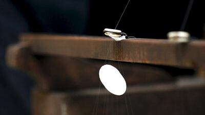 A frame spins a thread of silk from a cocoon on an antique loom. Alessandro Bianchi / Reuters