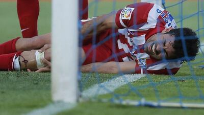 Atletico's Diego Costa holds his leg as he got injured after scoring during a Spanish Primera Liga match between Getafe and Atletico Madrid at the Coliseum Alfonso Perez stadium in Madrid, Spain, Sunday, April 13, 2014. AP Photo/Andres Kudacki