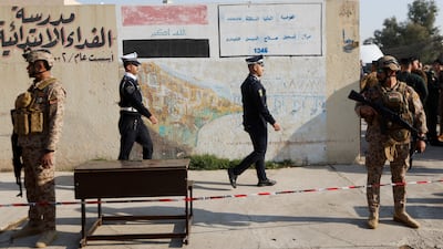 Iraqi security forces stand guard outside a polling station during special voting, two days before the polls open to the public, for a parliamentary election, in Mosul, Iraq. Reuters