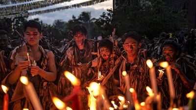 ALIAGA, PHILIPPINES - JUNE 24: Devotees covered in mud and dried banana leaves light candles as they take part in the Taong Putik ("mud people") Festival on June 24, 2019 in the village of Bibiclat in Aliaga town, Nueva Ecija province, Philippines. Each year, the residents of Bibiclat village in Aliaga town celebrate the Feast of Saint John by covering themselves in mud, dried banana leaves, vines, and twigs as part of a little-known Catholic festival. According to locals, the Taong Putik festival (literally meaning "mud people festival"), traces its history from the Pacific War and reenacts how rain stopped the execution of 14 villagers by Japanese soldiers in 1944. The townsfolk considered this as a miracle from Saint John, and every year since then the villagers roll in mud to show their gratitude to the saint. The Feast Day of Saint John the Baptist is celebrated throughout the country every June 24. The Philippines is the only Southeast Asian country with a predominantly Catholic majority. (Photo by Ezra Acayan/Getty Images)