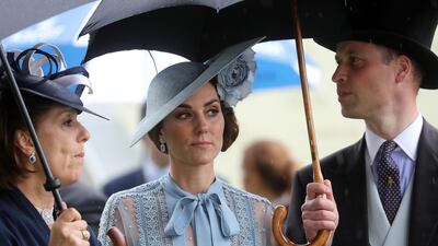 Prince William, Duke of Cambridge and Catherine, Duchess of Cambridge shelter from the rain. Getty Images