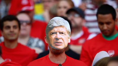 Arsenal fans are seen wearing Arsene Wenger face masks. Clive Mason / Getty Images