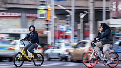 Brightly-coloured two-wheelers such as those from Ofo, left, and Mobike, right, are encouraging Chinese commuters to bike-share and cut down the country's urban congestion and pollution. Johannes Eisele / AFP