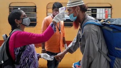 A health worker checks a train passenger’s temperature and pulse on a railway station platform in Mumbai, India, on April 7, 2021. Reuters