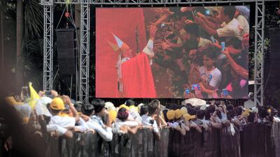 People standing outside St Mary's Cathedral watch Pope Francis greeting well-wishers after a mass in Yangon, Myanmar, on November 30, 2017. AFP