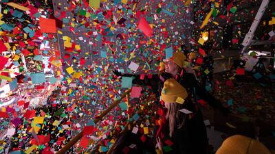 Times Square Alliance volunteers throw confetti as the clock strikes midnight during the New Year's Eve celebration in New York. AP