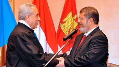 Mohammed Morsi (right) shakes hands with Faruq Sultan, head of the presidential election commission, after taking the oath of office at his swearing-in ceremony at the Constitutional Court in Cairo in June, 2012.