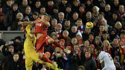 Liverpool's Martin Skrtel, centre, challenges for the ball against Swansea City keper Lukasz Fabianski, left, in their Premier League match on Monday. Peter Powell / EPA