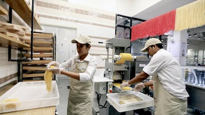 Sharmila Lama, left, and Bighneswor Parida prepare fresh pasta at Eataly. Sarah Dea / The National