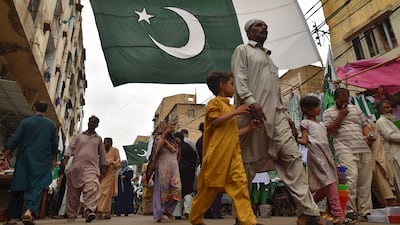 Pakistani flags hang over a market in Karachi selling items in the national colours ahead of the country's 76th Independence Day. EPA