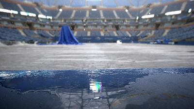 Rain falls on a tarp-covered Arthur Ashe Stadium after the US Open women's semi-final matches were postponed on Thursday until Friday. Kathy Willens / AP