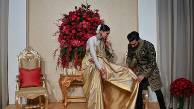 Padukone wore a gold sari by Angadi Galleria, while Singh chose an embroidered sherwani by Rohit Bal. Photo / AFP