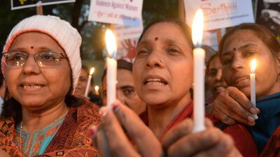 Demonstrators in New Delhi hold candles in honour of a physiotherapy student who was gang raped and murdered to mark the one year anniversary of her death on December 29, 2013. Sajjad Hussain / AFP