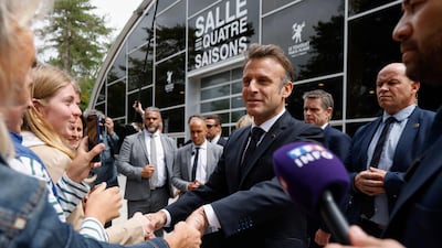 Mr Macron shakes hands with voters. AFP