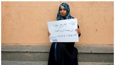 Syrian refugee Kamer Topalca, 18, as she holds a message that reads: “My god save us. Let us to return back to our homeland safe. Let us live happily” in Yayladagi refugee camp in Hatay province near the Turkish-Syrian border, Turkey.