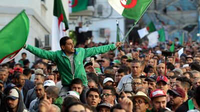 Demonstrators carry national flags during a protest against the country's ruling elite and rejecting December presidential election in Algiers, Algeria. Reuters