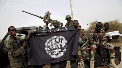Nigerian soldiers hold up a Boko Haram flag seized in the town of Damasak in 2015.