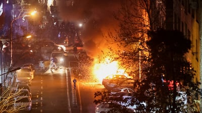 Cars burn on a street during protests in Tehran, on January 8. Reuters
