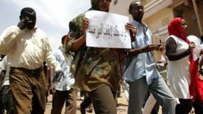 Lubna Hussein (second from right), a former journalist and UN press officer, carries a placard that reads "know your rights" as she leaves the courtroom after her trial.