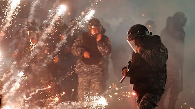 Lebanese riot policemen run from firecrackers fired by the supporters of the Shiite Hezbollah and Amal Movement groups. AP