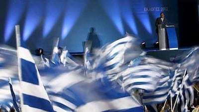 Supporters of the New Democracy party wave Greek flags as Antonis Samaras speaks during an election rally in Athens. AP Photo