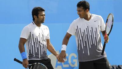 India's Mahesh Bhupathi, right, talks to partner Leander Paes during their double final tennis match against Bob Bryan and Mike Bryan of the US at the Queen's Club grass court championships in London. AP Photo/Sang Tan