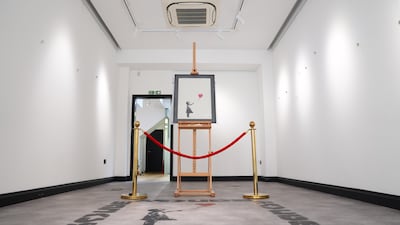 Banksy painting Girl With Balloon on display at the Grove Gallery in London after it was stolen on Sunday, then recovered and returned to the gallery. PA