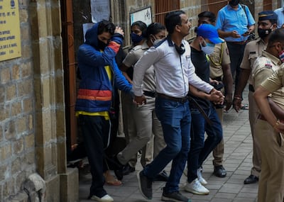 Bollywood actor Shah Rukh Khan’s son Aryan Khan, is escorted by law enforcement officials outside the Narcotics Control Bureau. AP