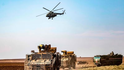 A Russian Mil Mi-17 military helicopter flies over a joint Russian-Turkish military patrol convoy in northeastern Syria, November 30, 2020. AFP