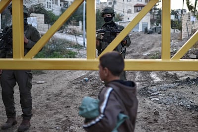 Israeli soldiers stand guard behind a barrier on the outskirts of Jenin. AFP