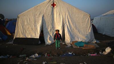 A young girl stands outside a Red Cross tent at the Hungarian border with Serbia in Roszke, Hungary. A record 4,000 people crossed the Hungarian border with Serbia on Saturday.