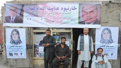 Afghan men sit next to campaign posters of candidates for the upcoming parliamentary on a shop in downtown Kabul, Afghanistan, 06 October 2018. EPA
