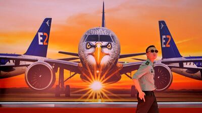A visitor walks past a poster featuring the Embraer E190-E2 E190-E2 Commercial Jets during the 12th China International Aviation and Aerospace Exhibition, also known as Airshow China 2018, in Zhuhai city, south China's Guangdong province.(AP Photo