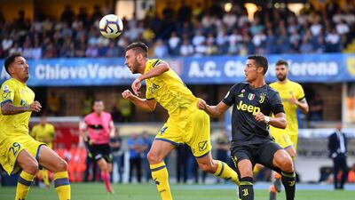 Cristiano Ronaldo goes for a ball with Chievo's defender Mattia Bani. AFP