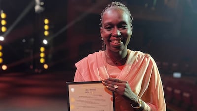 Nada Fadol holds up her UNHCR Nansen Refugee Award for the Middle East category. Photo: UNHCR