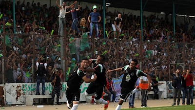 Palestinians cheer after players from Al Shujaiya score during their Gaza Strip Cup final against Rafah Club in Gaza City, on June 7, 2015. Mahmud Hams / AFP