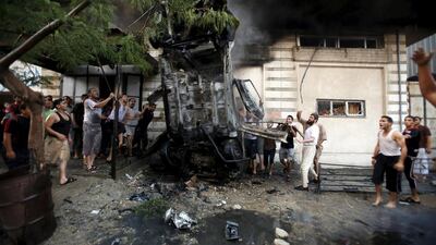 Palestinians inspect a car after it was blown up in Gaza City on July 19, 2015. Suhaib Salem/Reuters