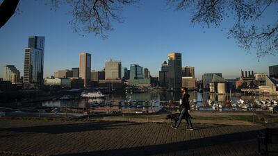 A pedestrian walks a dog at Federal Hill park in Baltimore, Maryland. Coronavirus infections continue to rise in the greater Washington region, with more than 5,000 new cases reported on Thursday, a daily record. Bloomberg
