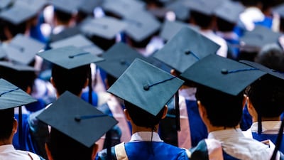 Rear view of the university graduates in graduation gowns and caps. Getty Images