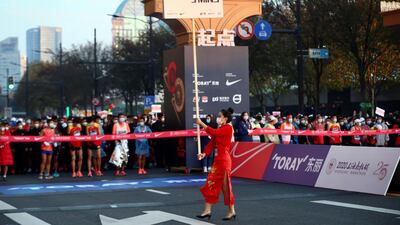 A woman holds a countdown placard before the start of the 2020 Shanghai marathon. AFP