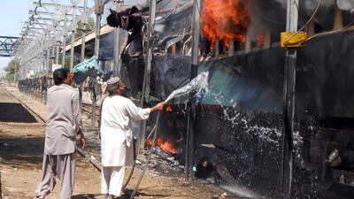 A Pakistani railway official extinguishies fire after a bomb blast on a train at the Sibi railway station. Khalid Hussain / AFP