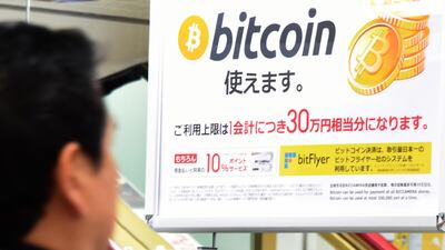 A man walks past a poster that informs customers that bitcoin can be used in this shop in Tokyo. Bitcoin is recognised as legal tender in the world's third-biggest economy. prices of Cryptocurrencies slumped on Friday after one of Japan’s biggest Bitcoin venues halted client withdrawals. Toru YAMANAKA / AFP