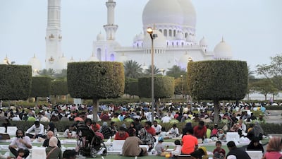 During Ramadan, people gather to break their fast outside the Sheikh Zayed Grand Mosque. Pawan Singh / The National