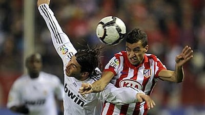 Atletico's Simao, right, and Real's Sergio Ramos go up for the ball in November's derby.
