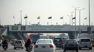 Pakistani commuters drive their vehicles under a banner welcoming Mohammed bin Salman in Islamabad. AFP